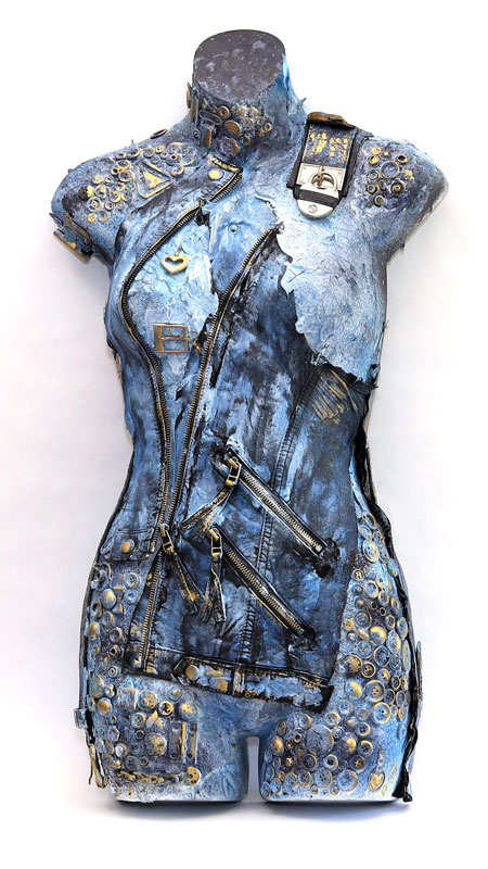 Pieces of leather and lace combined with textures and found objects are adhered to a hanging body form. Shades of denim blue and black with gold accents on this mixed media piece. 30” x 16”. by Natalie Oliphant