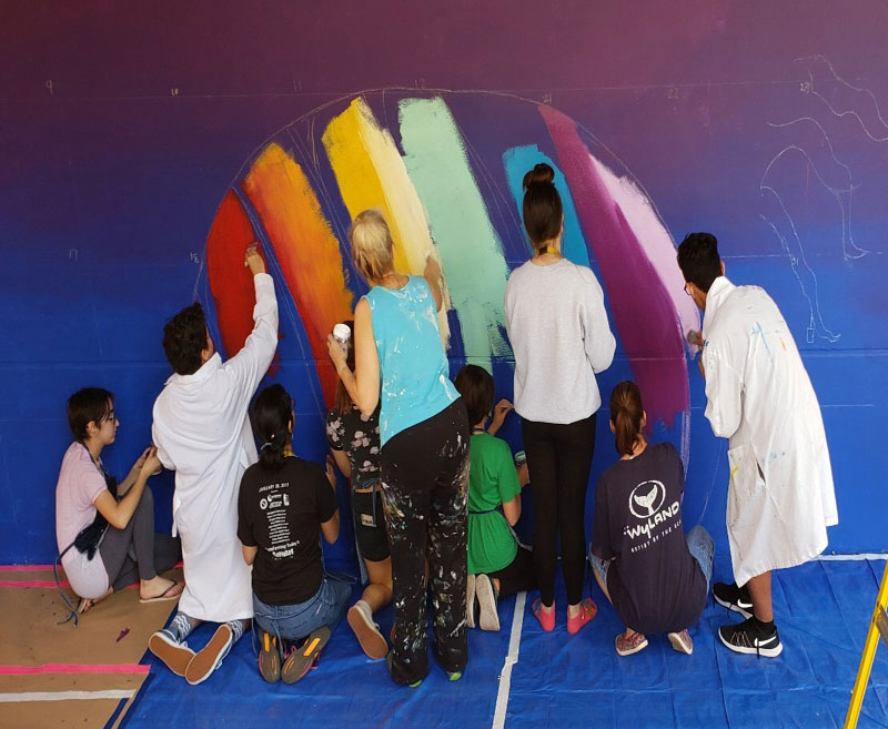 students painting the rainbow in the art mural project at Parkland